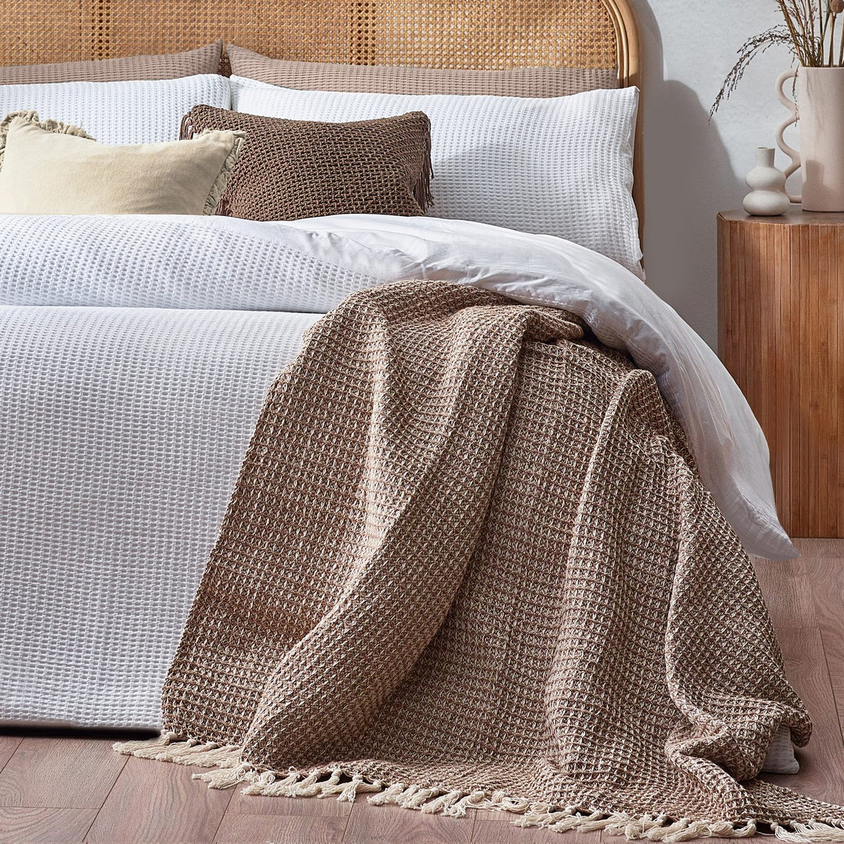 White Chunky Waffle cotton duvet cover set on a bed with matching pillowcases, styled with cushions and a brown waffle-textured throw in a bedroom setting.