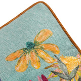 Close-up of the Country Wilds Blossom Meadow cushion corner, showing a hand-painted orange daisy on sky-blue polyester fabric with a rust-coloured piped edge.