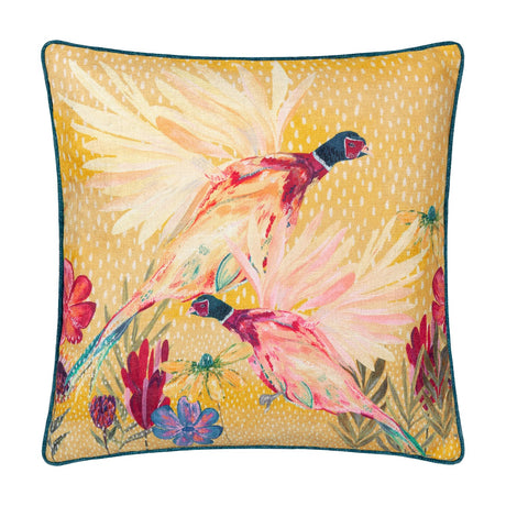 Country Wilds Pheasant Bloom polyester cushion in gold, printed with two flying pheasants, cream feathering, and wildflowers, teal piped edge, on a white background.