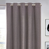 Dawn Plain Reversible Eyelet Curtains in charcoal, hanging from a brushed metal pole through silver eyelets, showing textured fabric folds in a room setting.