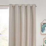 Dawn Linen Reversible Eyelet Curtains in natural linen-look polyester with brushed metal eyelets, shown hanging on a rod against a light wall in a living room setting.