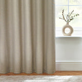 Dawn Plain Reversible Eyelet Curtains in natural marl fabric, shown in soft folds beside a window with a round ceramic vase and greenery on the sill.