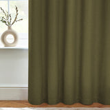 Dawn Plain Lined Eyelet Curtains in olive green fabric with soft textured weave, shown hanging in a soft furnishings arrangement beside a window with a cream vase on the sill.