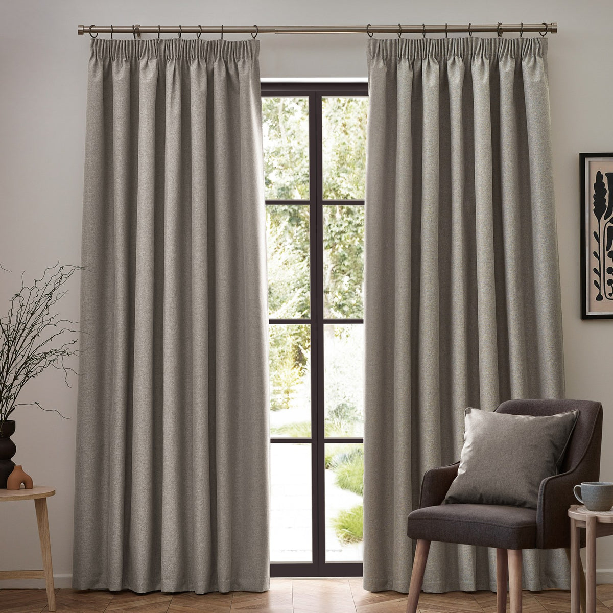Dawn pencil pleat curtains in linen, floor-length pair with pencil pleat heading on a pole, shown either side of a garden door in a living room.