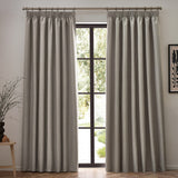Dawn pencil pleat curtains in linen, pair of full-length beige woven curtains with pencil pleat heading hung either side of a black-framed window in a living room.