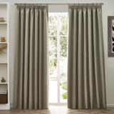 Dawn pencil pleat curtains in natural marl-effect polyester, hung either side of a French door in a living room with white shelving and wooden flooring.