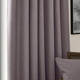 Dawn pencil pleat curtains in charcoal grey, textured polyester fabric with pencil pleat heading, shown hanging in soft folds beside a cushion and framed artwork.