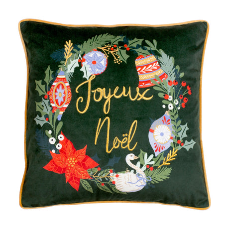 Pine green velvet square cushion with printed Christmas wreath of holly, baubles, poinsettia and a goose, gold "Joyeux Noel" embroidery and gold piping, on a white background.
