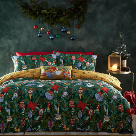 Deck The Halls polycotton duvet cover set in pine green, printed with baubles, poinsettias, animals and foliage, styled on a bed with matching pillowcases and a red cushion trim.