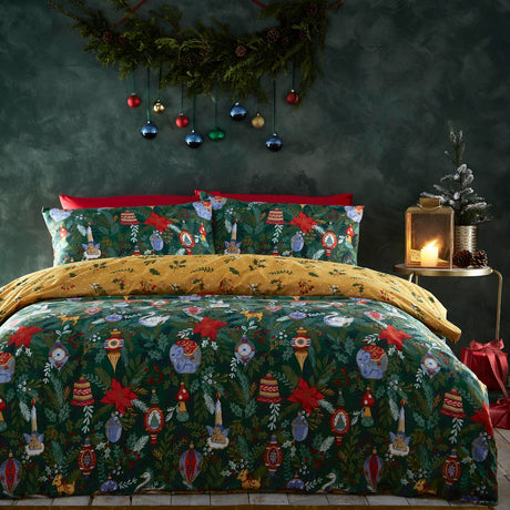 Pine green Deck The Halls polycotton duvet cover set with baubles, poinsettias, swan, deer and elephant motifs, mustard reverse and matching pillowcases, styled on a bed in a festive bedroom.