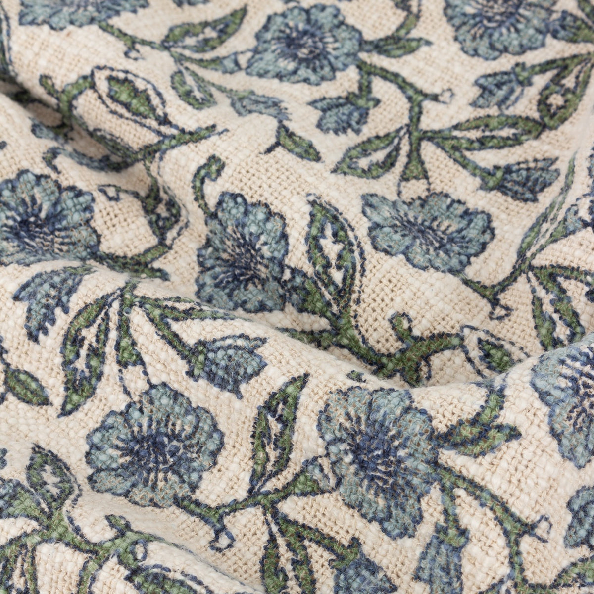 Delphine Floral Cotton Throw in Delph Blue, close-up of woven cream cotton with a scattered blue and green floral print, showing the fabric's textured, loosely woven surface.