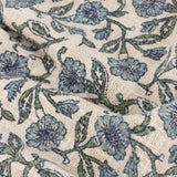 Delphine Floral Cotton Throw in Delph Blue, close-up of woven cream cotton with a scattered blue and green floral print, showing the fabric's textured, loosely woven surface.