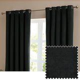Black velvet eyelet curtains hung on a brushed metal pole beside a window, shown with a fabric swatch highlighting the soft matt pile texture.
