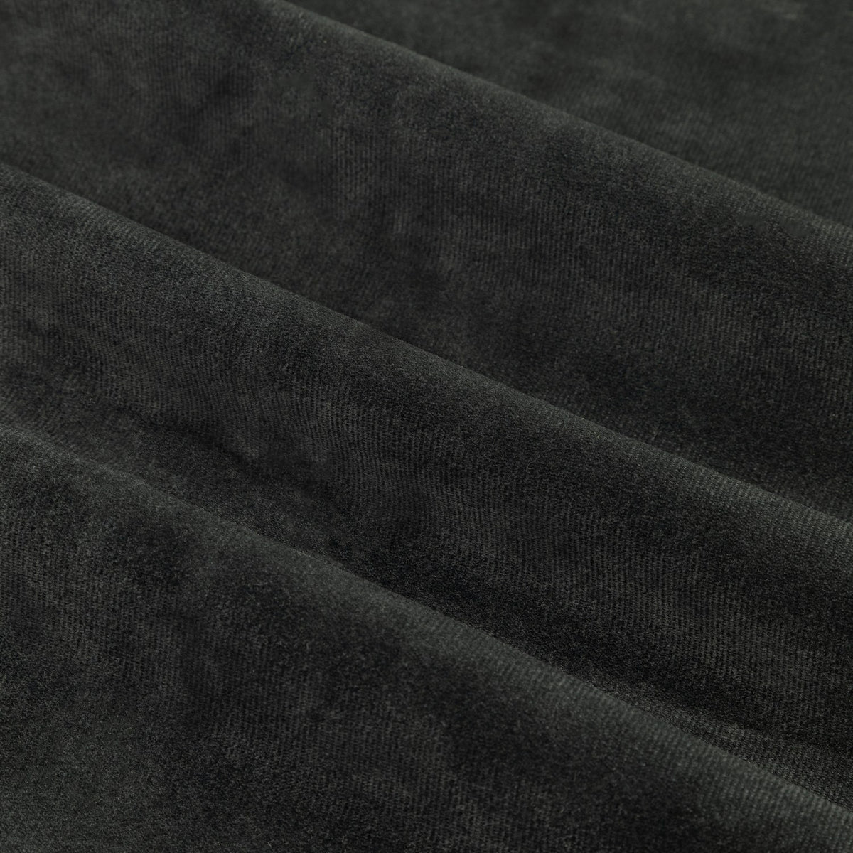 Close-up of The Ultimate Velvet Plain Lined Eyelet Curtains in black, showing soft matt velvet pile with folds catching light across the polyester fabric.