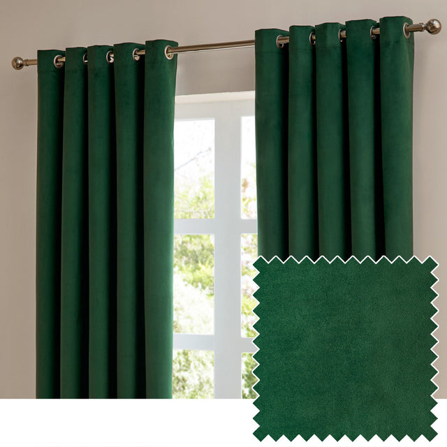 Emerald green velvet eyelet curtains with silver grommets hung on a metal pole beside a window, shown with a fabric swatch sample.