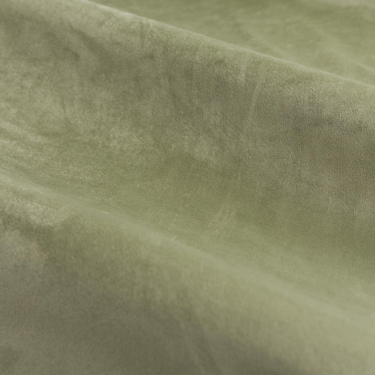 Close-up of The Ultimate Velvet Plain Fully Lined Eyelet Curtains in green, showing the soft, dense velvet pile and matte polyester fabric with folds catching the light.