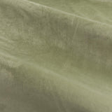 Close-up of The Ultimate Velvet Plain Fully Lined Eyelet Curtains in green, showing the soft, dense velvet pile and matte polyester fabric with folds catching the light.