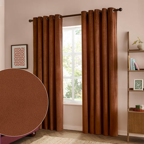 Rust-brown velvet eyelet curtains hanging fully lined either side of a window in a pink-toned bedroom, with a fabric swatch inset showing the plain matt velvet texture.