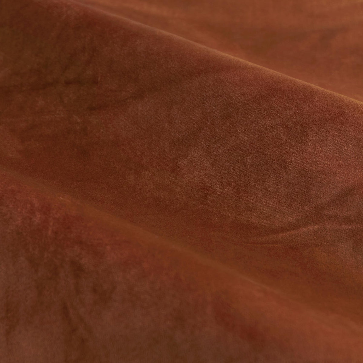 Close-up of The Ultimate Velvet Plain Fully Lined Eyelet Curtains in Mink, showing soft-pile matt velvet fabric in warm rust brown with gentle folds.