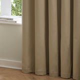Mocha brown velvet eyelet curtains with soft draping folds, shown against a light room setting with a windowsill and wooden flooring.