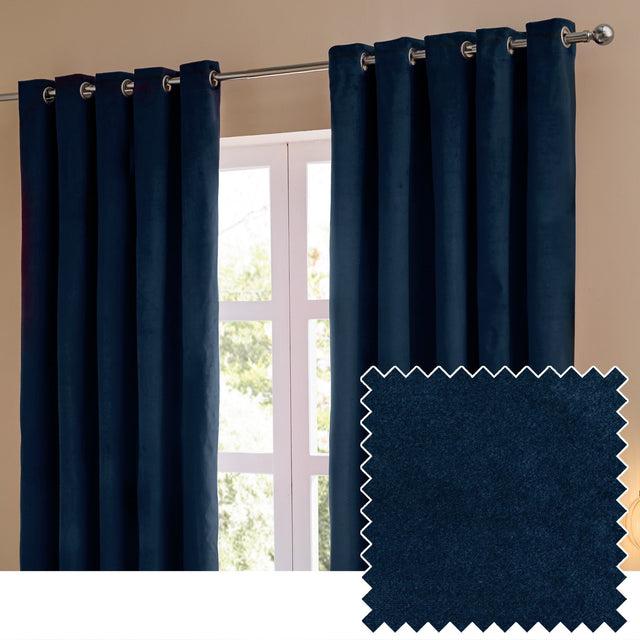 Royal blue velvet eyelet curtains hanging from a chrome pole beside a window, shown with a matching fabric swatch, matt finish and rounded folds.
