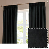 Black velvet pencil pleat curtains with pinch-pleat heading hung on a brass pole in a living room window, shown alongside a black fabric swatch.