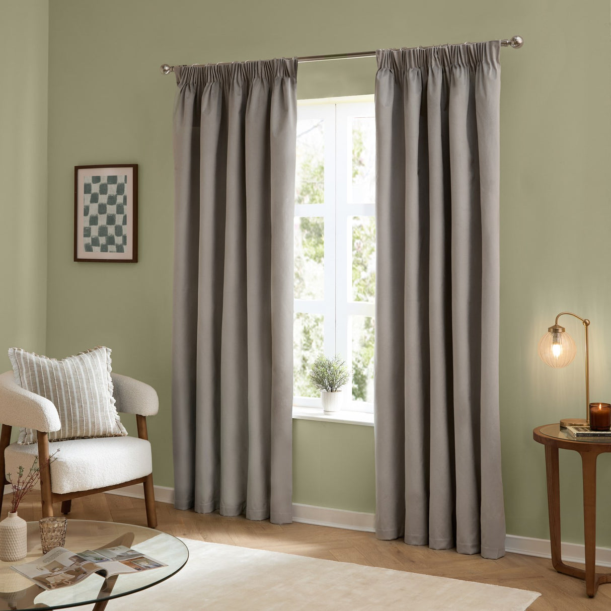 Silver-grey velvet pencil pleat curtains in soft matte polyester, hung in deep folds on a chrome pole in a green-walled living room.