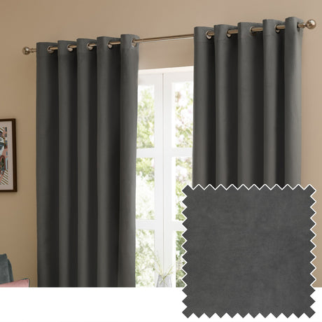 Charcoal grey velvet eyelet curtains hanging in a living room window, shown with a fabric swatch highlighting the smooth matt velvet texture.