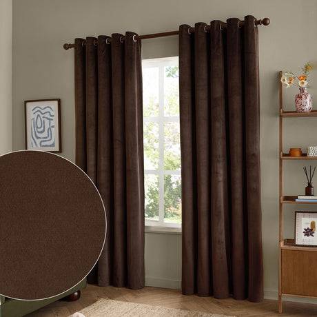 Chocolate-brown velvet eyelet curtains hanging in soft folds on a pole either side of a window in a living room, with a fabric swatch shown inset.