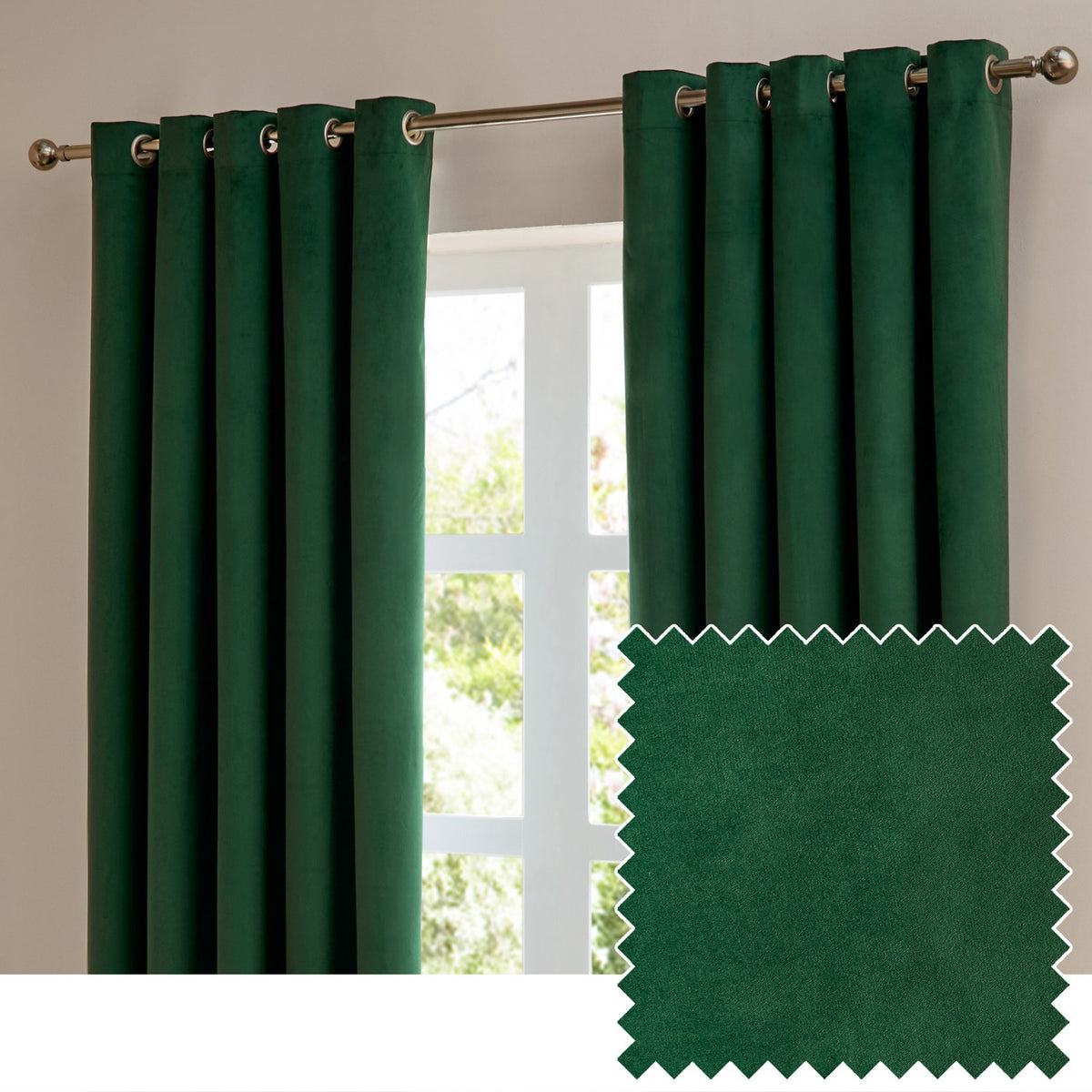 Emerald green velvet eyelet curtains hanging on a chrome rod by a window, shown with a fabric swatch sample of the same matt velvet material.