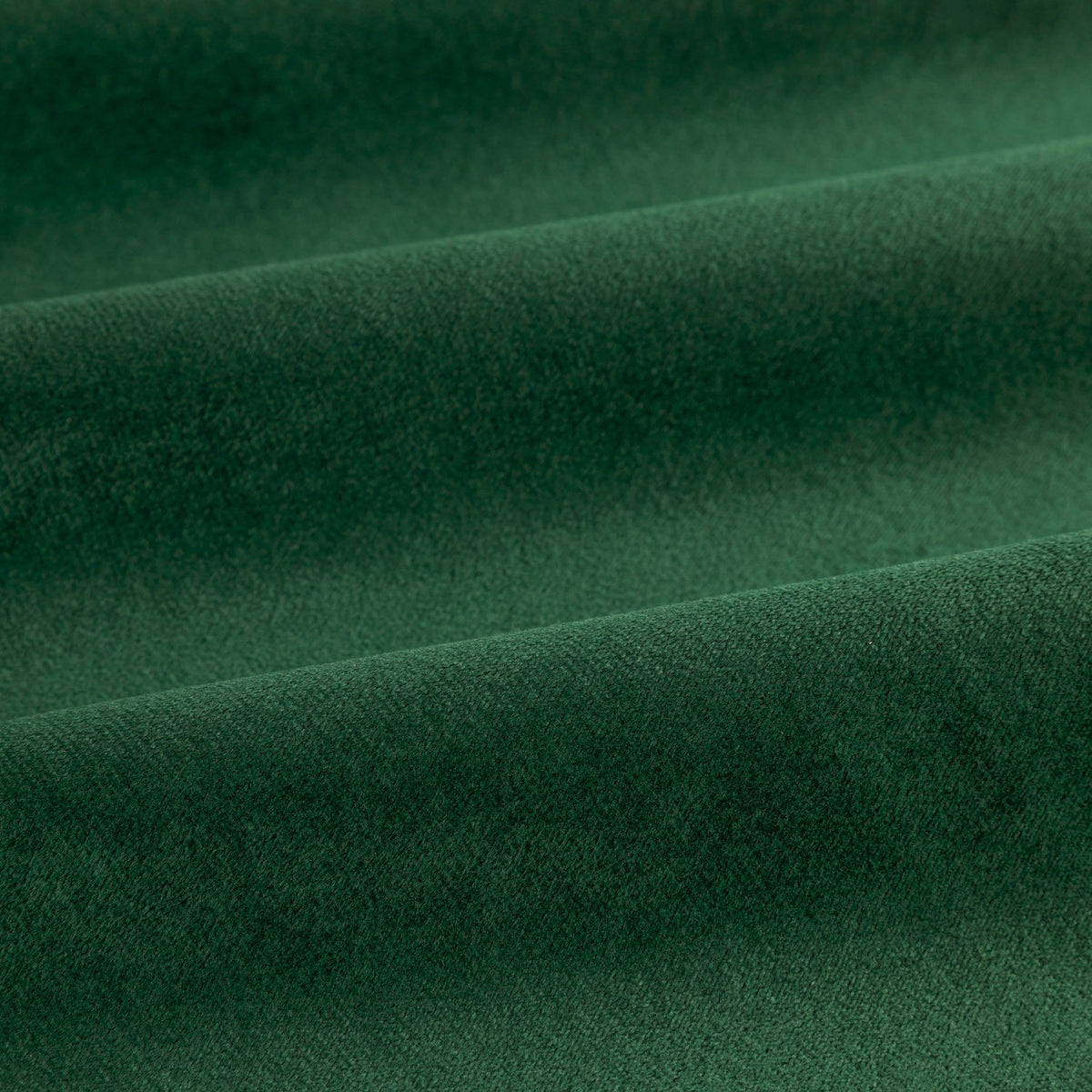 Close-up of The Ultimate Velvet Plain Lined Eyelet Curtains in emerald green, showing soft, short-pile velvet fabric with soft folds and a matt finish.