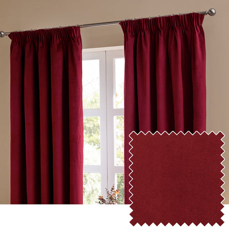 Burgundy velvet pencil pleat curtains hanging either side of a white-framed window, shown with a fabric swatch in matching deep red on a neutral background.