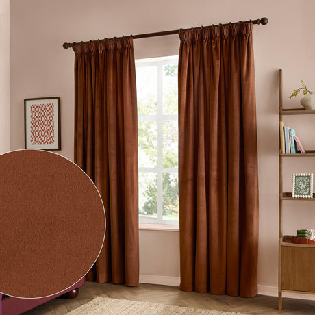 Rust-brown velvet pencil pleat curtains with a soft matt finish hang beside a window in a bedroom, with a fabric swatch inset showing the plain velvet texture.