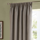 Silver-grey velvet pencil pleat curtains with pinch-pleated heading and rings, shown hanging on a metal pole beside a window in a green-walled room.