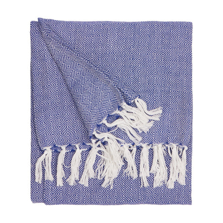 Dessa cobalt blue polyester throw with small-scale geometric diamond pattern and knotted white fringing, folded on a plain white background.