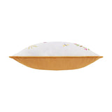 Side view of the Daisy Hill Agnes cushion showing a white velvet top with floral and dragonfly embroidery and a tan velvet base, on a plain background.