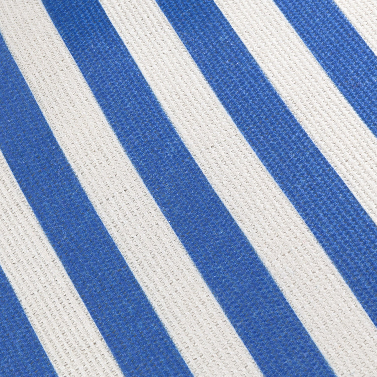 Close-up of the Deck Stripe reversible polyester cushion fabric, showing bold diagonal blue and white woven stripes.