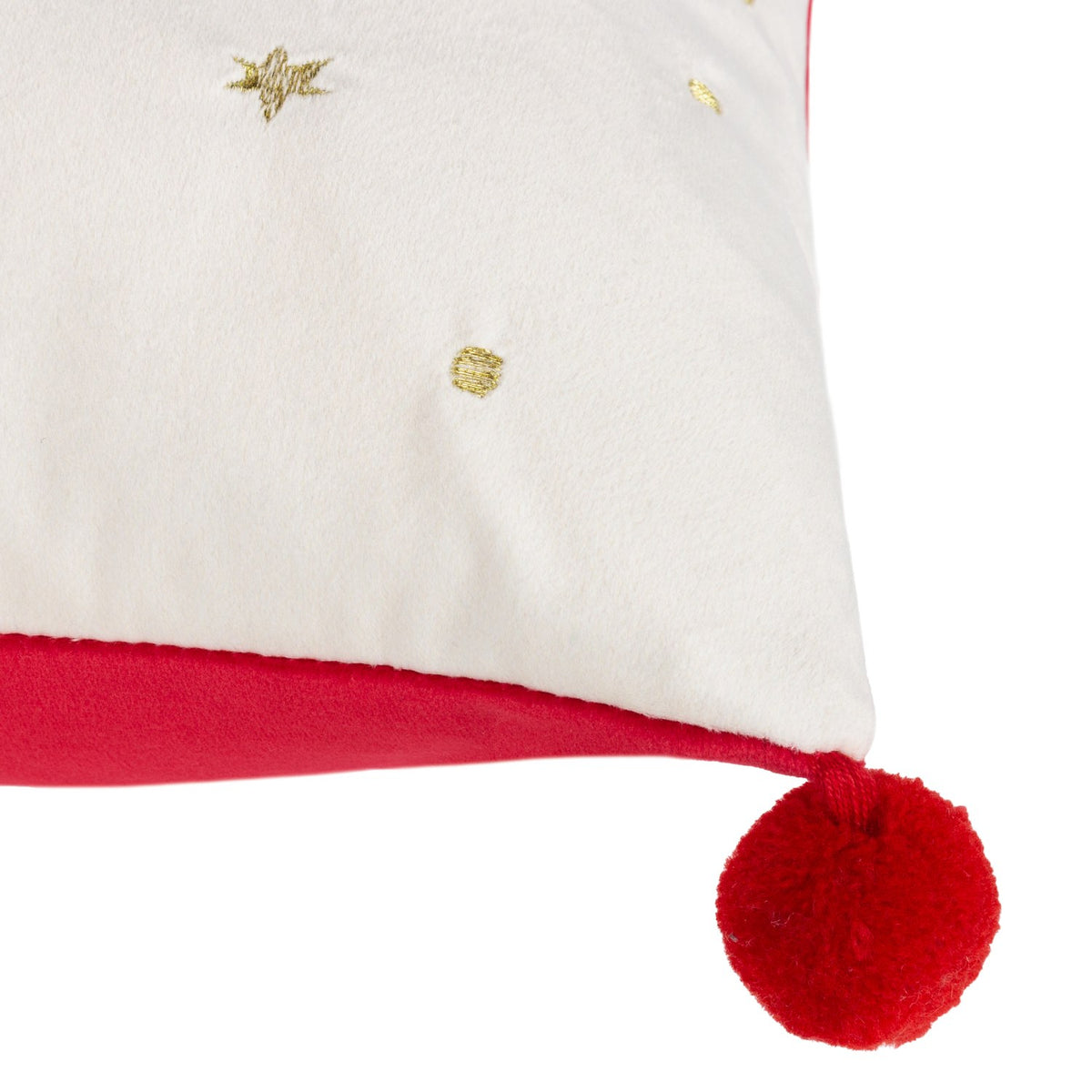 Close-up of the Deck The Halls velvet cushion corner, showing ivory fabric with gold star and dot embroidery, a red velvet trim, and a red pom-pom tassel.