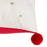 Close-up of the Deck The Halls velvet cushion corner, showing ivory fabric with gold star and dot embroidery, a red velvet trim, and a red pom-pom tassel.