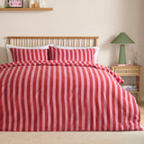 Dual Tone Printed Striped Duvet Cover Set in pink and red on a bed with matching pillowcases, styled with a wooden spindle headboard in a bedroom setting.