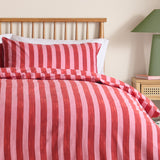 Dual Tone Printed Striped Duvet Cover Set in pink and red, shown on a bed with matching pillowcase against a wooden spindle headboard in a bedroom setting.
