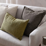 Dune Velvet Chenille Cushion in Mole, a square mid-brown textured cushion with subtle sheen, styled on a light grey sofa with green and patterned cushions.