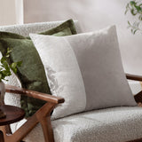 Dune Velvet Chenille Cushion in Moss green with an oxford edge, shown on a light bouclé armchair alongside a beige linen cushion.