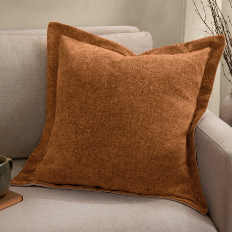 Dune Velvet Chenille Cushion in Pecan, a square brown cushion with a wide flat oxford border, shown on a light grey sofa in a living room setting.