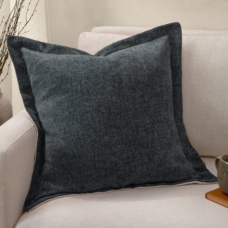 Dune Velvet Chenille Cushion in Slate, a square textured chenille cushion in deep blue-grey with flanged edge, shown on a beige sofa.