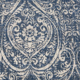 Close-up of the Durelle Damask Cotton Cushion in Delph Blue, showing a scrolling medallion and floral damask pattern printed in deep blue on cream slub cotton.