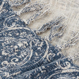 Close-up of the Durelle Damask Cotton Throw in Delph Blue, showing the scrolling ivory-cream damask pattern, woven edge, and knotted fringe against the plain cream reverse.