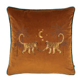 Dusk Animal Velvet Cushion in rust-orange velvet with embroidered facing monkeys, palm trees, crescent moon and stars in gold and brown thread, green piped edge, on a white background.