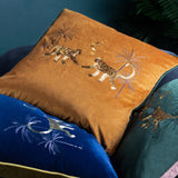 Dusk Animal Velvet Cushion in rust-orange with gold-thread embroidered monkeys, palm trees, moon and stars, shown alongside blue and green velvet cushions.