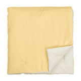Edie Linen Cotton Bedspread in butter yellow, quilted velvet folded to reveal a pale natural linen-look reverse, shown on a plain white background.